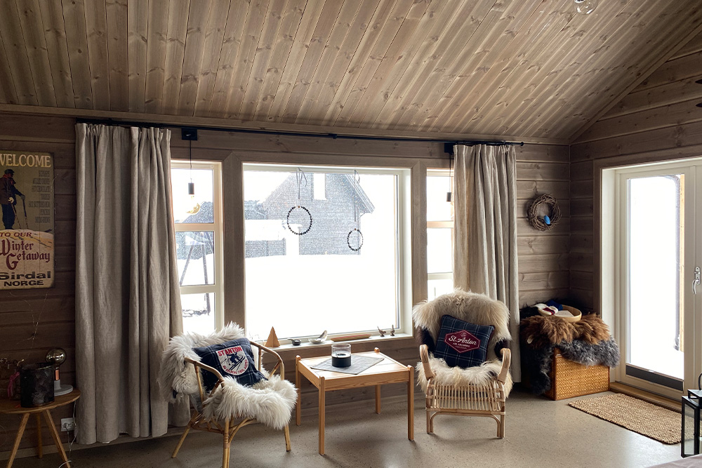 Bilde av hytte med drivvedgrå glattpanel og østerdalspanel. Finalist nummer 2 hytteprisen 2022.