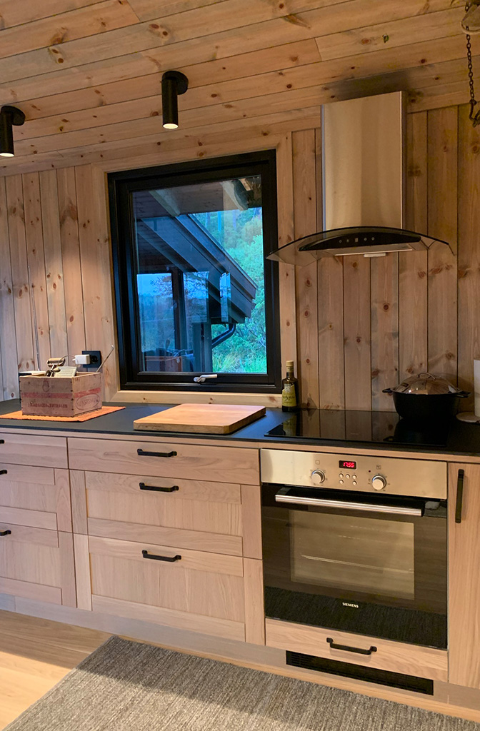 Bilde av kjøkken på hytta. Nytt kjøkken og nytt panel på vegger og i tak. Finalist nummer 5 - hytteprisen 2022.