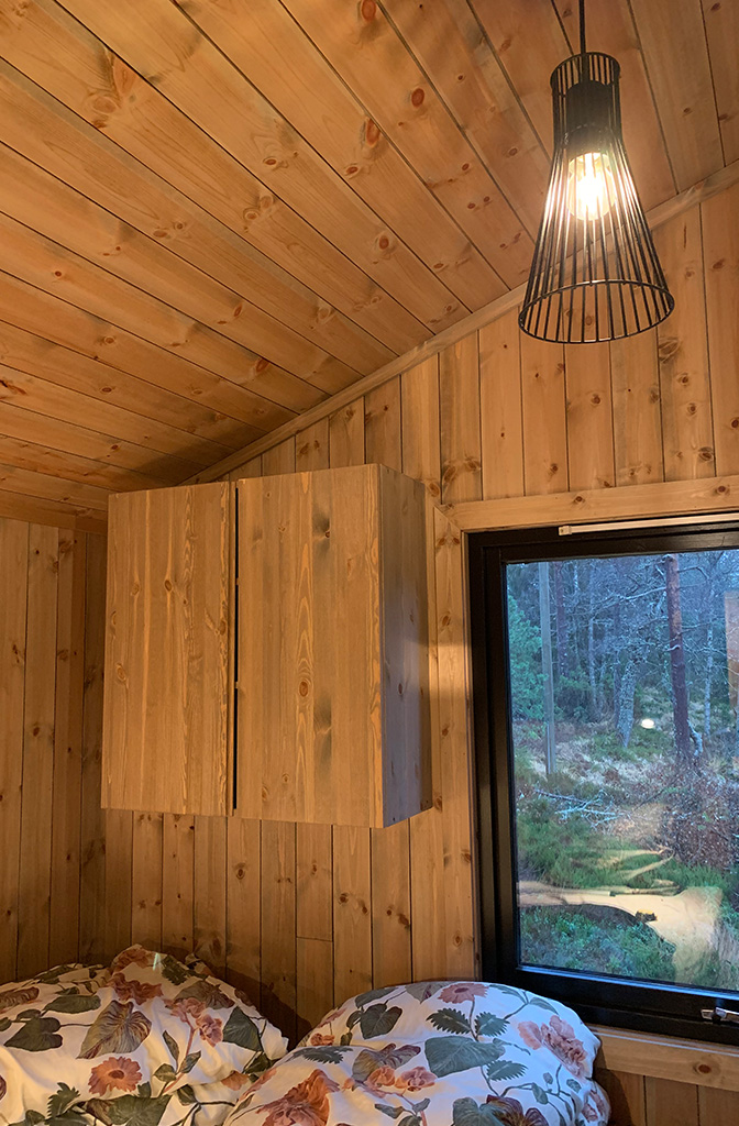Bilde av hjemmesnekret møbel på hytta. Soverom met har nytt panel og nye vinduer. Finalist nummer 5 i hytteprisen 2022.